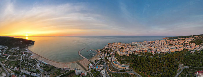 High angle view of townscape by sea against sky