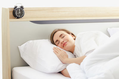 Portrait of young woman sleeping in bed