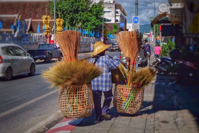 Person carrying brooms