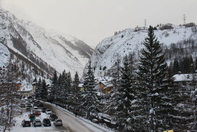 Snow covered trees and mountains against sky