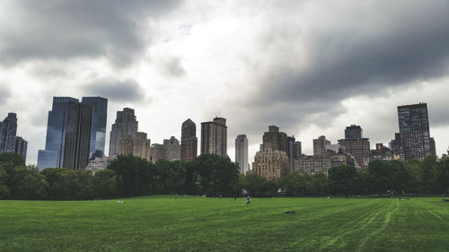 View of park in city against cloudy sky