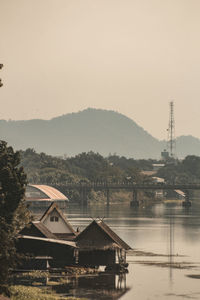 View of factory by buildings against sky