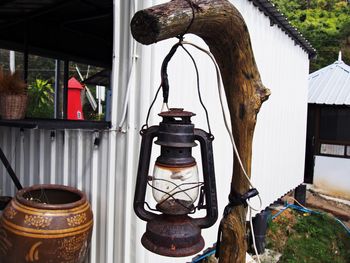 Close-up of electric lamp hanging outside house