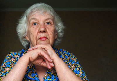Close-up of thoughtful senior woman sitting at home