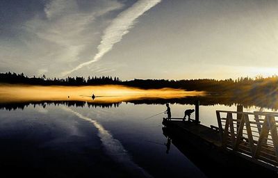 Pier on lake at sunset