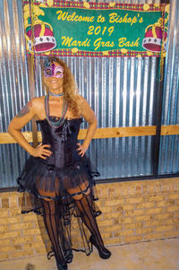Portrait of young woman standing against wall