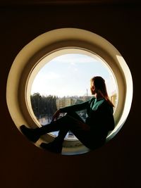 Woman sitting on window sill