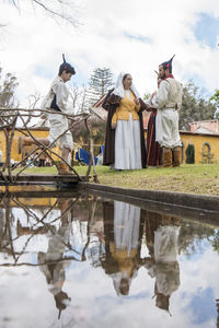 Rear view of people standing by lake