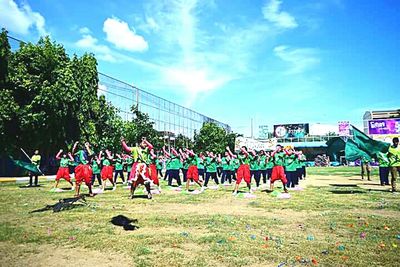 Crowd playing soccer against blue sky