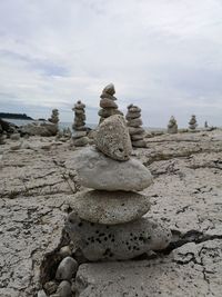 Stack of stones on rock against sky