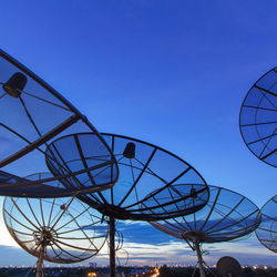 Low angle view of ferris wheel against clear blue sky