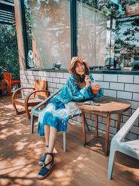 Portrait of woman sitting on chair at cafe