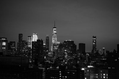 Illuminated buildings in city against sky at night