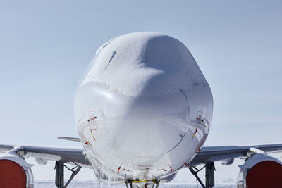 Snow covered cockpit of commercial airplane. front view of plane after snowfall.