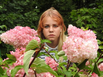 Portrait of girl by pink flowering plants