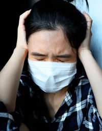 Close-up portrait of young man covering face