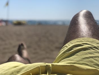 Low section of man lying on sand