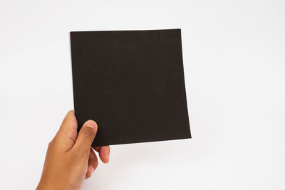 Hand holding book against white background