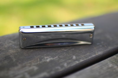 Close-up of harmonica on wooden plank