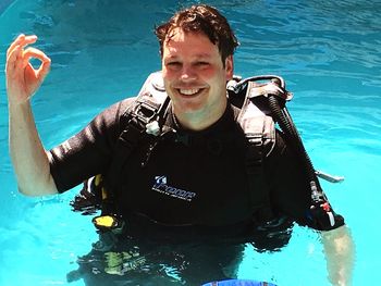 Portrait of smiling young man holding underwater