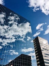 Low angle view of skyscrapers against blue sky