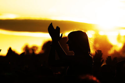 Silhouette woman against sky during sunset