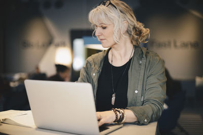 Businesswoman using laptop at desk in office