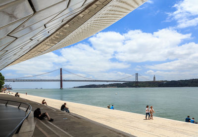 People on suspension bridge over river