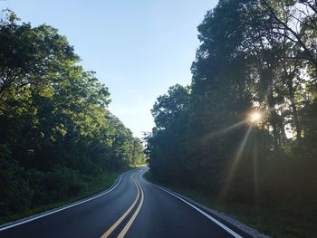 Road amidst trees against sky