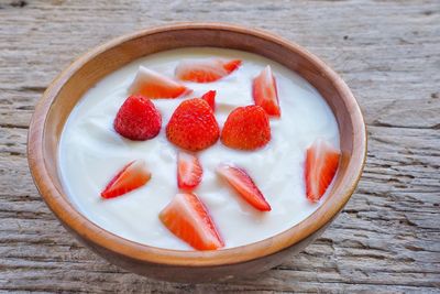High angle view of chopped strawberries in bowl on table