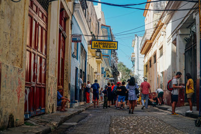 People walking on street amidst buildings in city