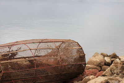 Fishing net on rock by sea