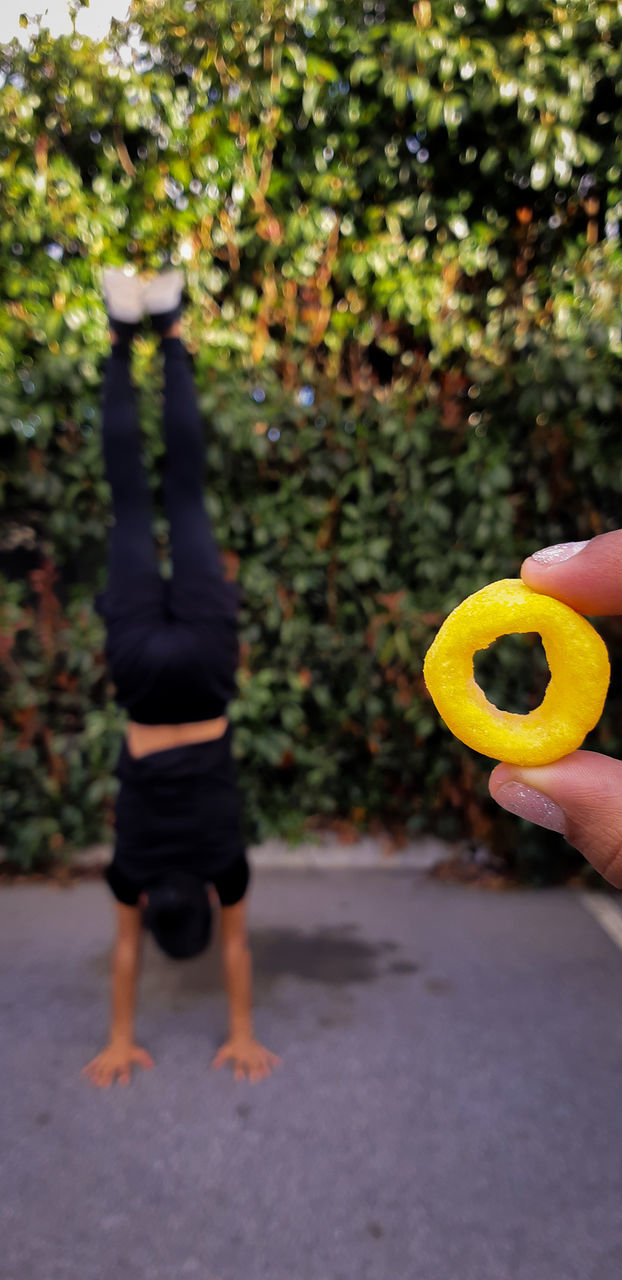 real people, yellow, lifestyles, hand, leisure activity, focus on foreground, human body part, human hand, day, holding, men, childhood, plant, outdoors, nature, full length, women