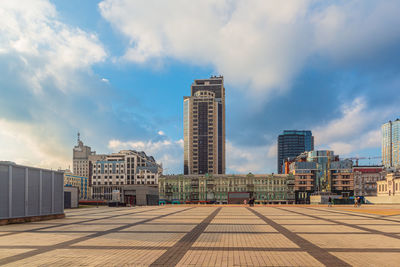 Buildings in city against cloudy sky