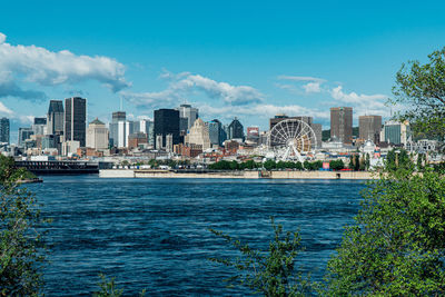 Sea and buildings in city against sky