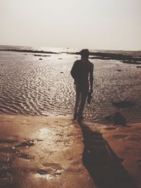 Rear view of man standing on beach