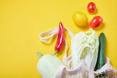 Close-up of fruits on table against yellow background