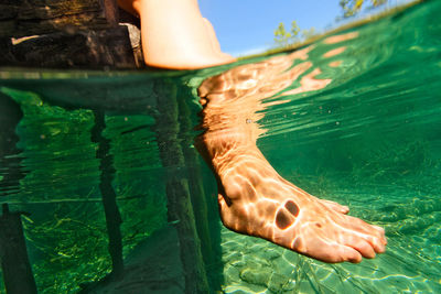 Underwater view of woman legs in plitvice lakes, croatia