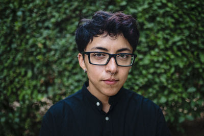 Close-up view of a transgender person posing on natural background.