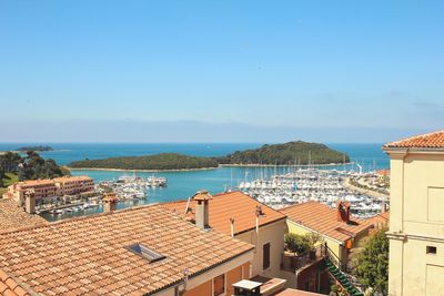 High angle view of town by sea against clear sky