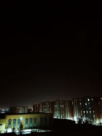 Low angle view of illuminated buildings against sky at night