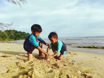 Boy playing with sand at beach