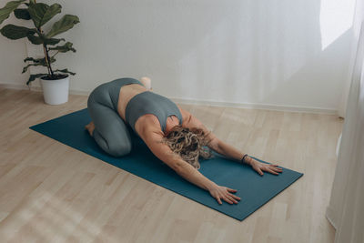 Full length of woman sitting on floor at home