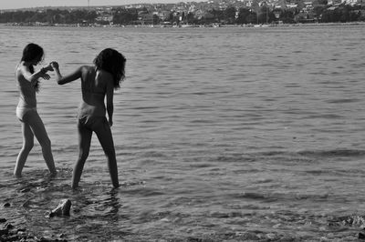 Side view of two people enjoying in sea