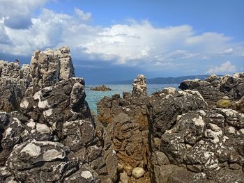 Rock formation on beach against sky
