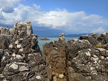 Rock formation on beach against sky