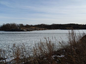 Scenic view of lake against sky during winter