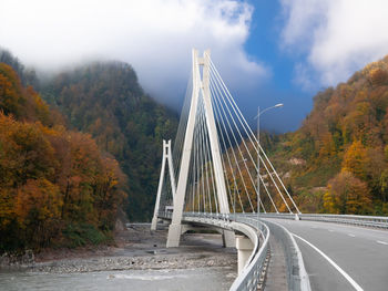 Bridge by road against sky during autumn