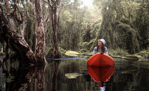 Asian traveler woman kayaking in mangrove forest of botanical garden, thailand. landscape travel 