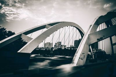 Bridge over river against cloudy sky